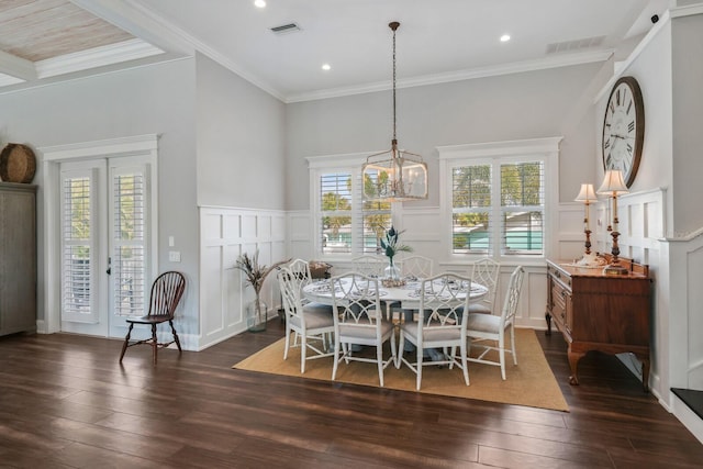 dining space featuring crown molding, dark wood finished floors, visible vents, and a decorative wall