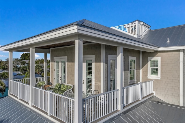 exterior space with metal roof, french doors, a standing seam roof, and a balcony