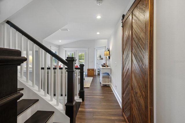 foyer featuring a barn door, lofted ceiling, dark wood-type flooring, stairs, and recessed lighting