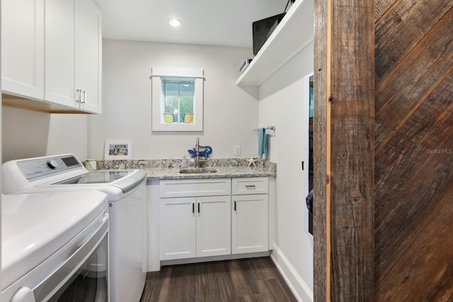 clothes washing area featuring recessed lighting, dark wood-type flooring, a sink, washer and dryer, and cabinet space