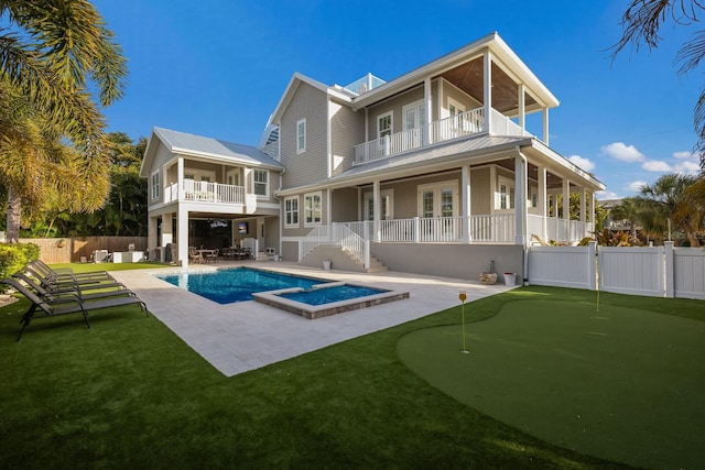 rear view of house featuring a lawn, a fenced in pool, a balcony, a patio, and a fenced backyard