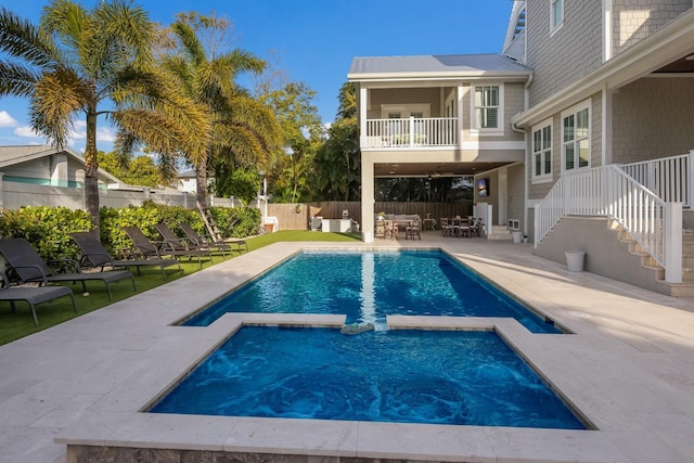 view of swimming pool featuring a fenced backyard, a pool with connected hot tub, an outdoor living space, and a patio