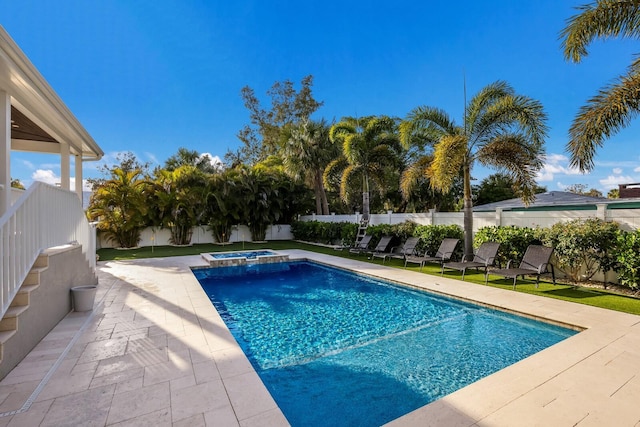 view of swimming pool featuring a patio area, a fenced backyard, and a pool with connected hot tub