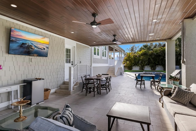 view of patio featuring ceiling fan, a jacuzzi, an outdoor living space, and outdoor dining space