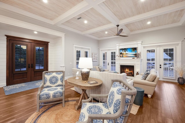 living area with french doors, beamed ceiling, and wood finished floors