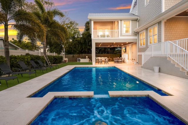 view of swimming pool with a pool with connected hot tub, a patio area, outdoor lounge area, and fence