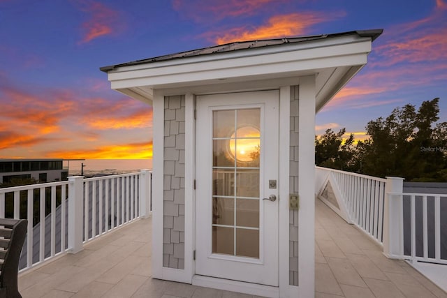 exterior entry at dusk featuring a balcony