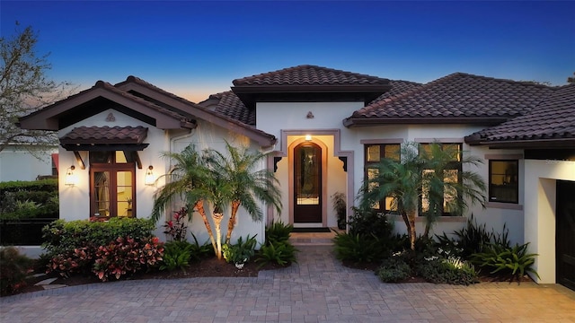 mediterranean / spanish house featuring stucco siding and a tile roof