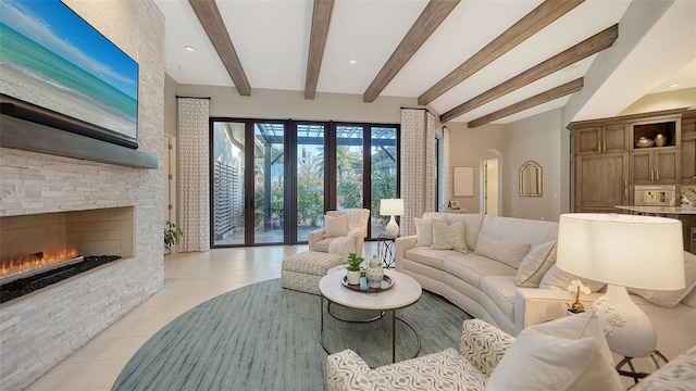 living room featuring arched walkways, beam ceiling, and a fireplace