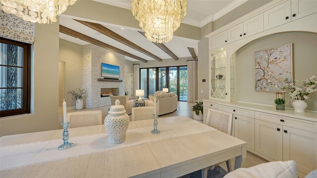 interior space with beamed ceiling, a large fireplace, a notable chandelier, and crown molding