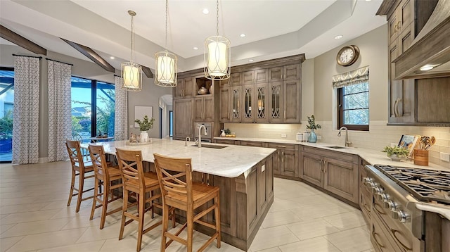 kitchen featuring stove, tasteful backsplash, arched walkways, and a sink