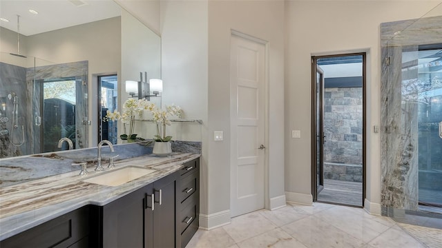 bathroom featuring a stall shower, vanity, and baseboards