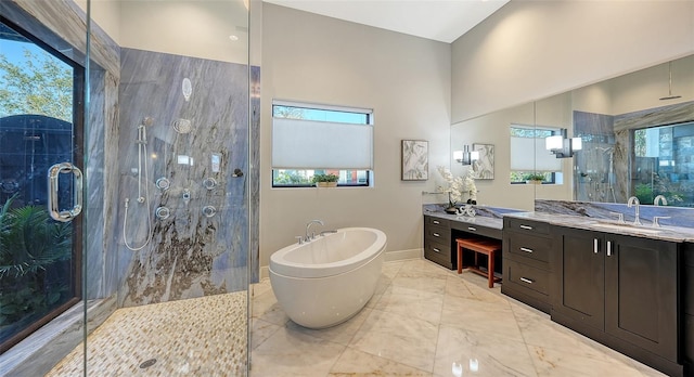 bathroom featuring a freestanding tub, marble finish floor, a healthy amount of sunlight, and a stall shower