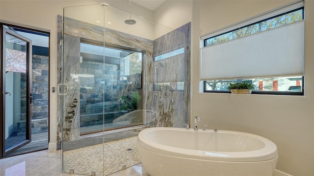 bathroom with a shower stall and a freestanding tub