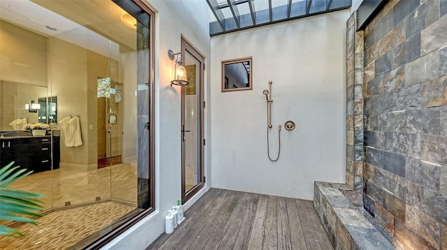 full bath featuring a stall shower, vanity, and hardwood / wood-style flooring