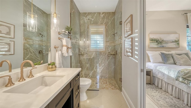 ensuite bathroom with a marble finish shower, tile patterned flooring, toilet, ensuite bathroom, and vanity