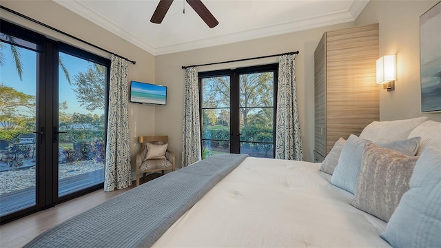 bedroom featuring french doors, wood finished floors, ornamental molding, and a ceiling fan