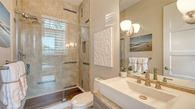 bathroom featuring a sink, toilet, and a shower stall