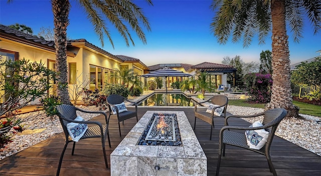 wooden deck featuring a gazebo and a fire pit