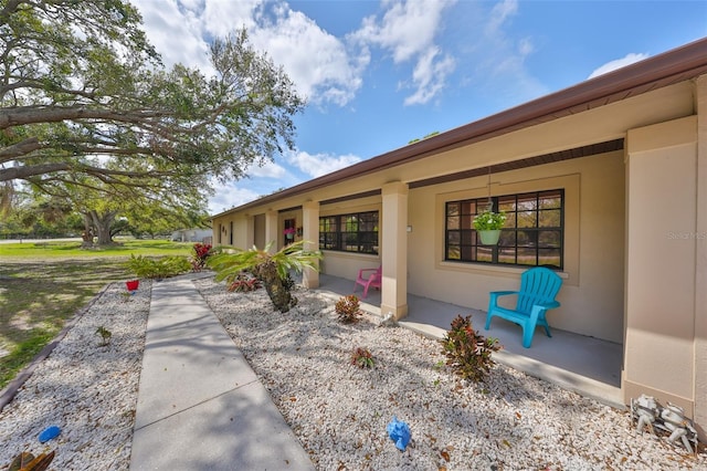 exterior space with a porch and stucco siding