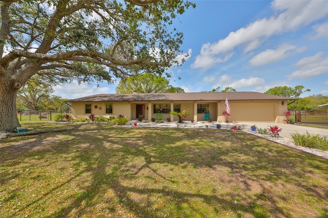 ranch-style home featuring a garage, a front yard, fence, and stucco siding