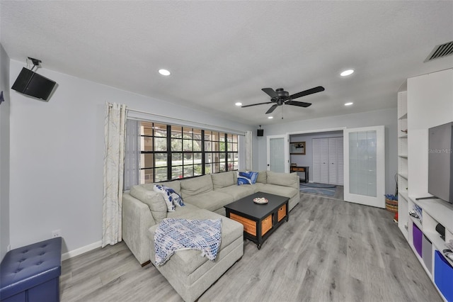 living area featuring baseboards, visible vents, wood finished floors, a textured ceiling, and recessed lighting