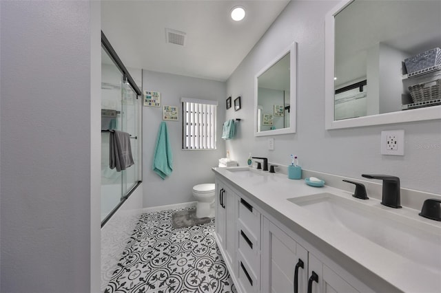 bathroom featuring visible vents, a sink, toilet, and double vanity