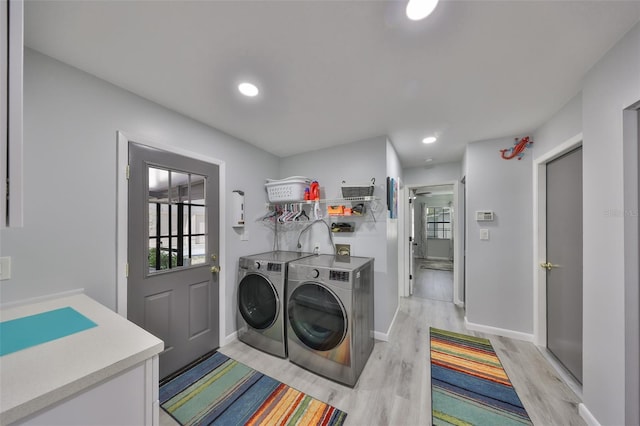 clothes washing area with light wood-style flooring, recessed lighting, laundry area, baseboards, and washer and dryer