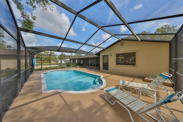 outdoor pool with glass enclosure and a patio