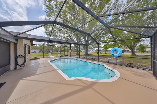 pool with glass enclosure and a patio area