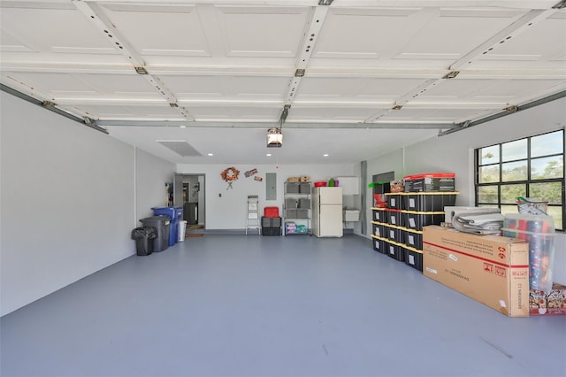 garage with freestanding refrigerator and electric panel