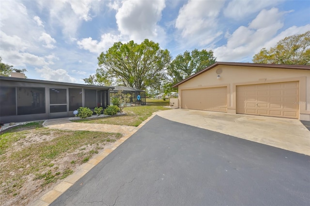 view of side of property with a garage, a lawn, a chimney, and stucco siding