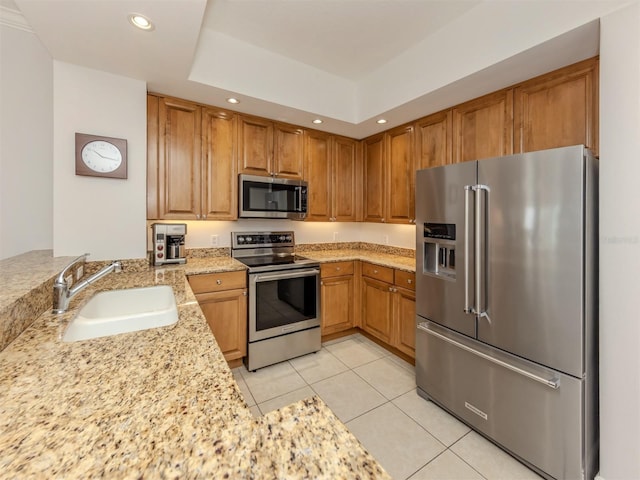 kitchen with light tile patterned floors, recessed lighting, a peninsula, a sink, and appliances with stainless steel finishes