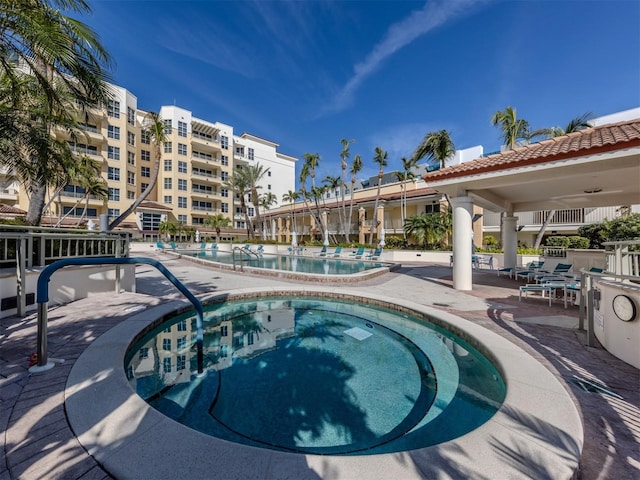 community pool featuring a community hot tub and a patio