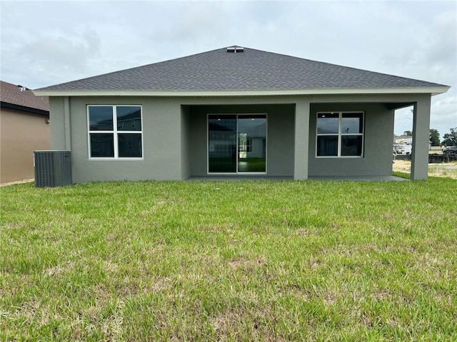 286 Hillshire Pl, Spring Hill, FL 34609 - rear view of house with stucco siding, a yard, and roof with shingles