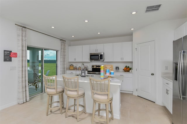 kitchen featuring stainless steel appliances, light countertops, visible vents, white cabinetry, and a sink