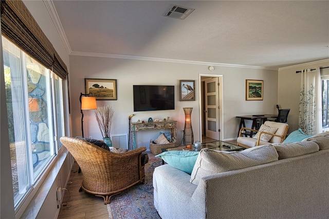 living room featuring visible vents, crown molding, and wood finished floors