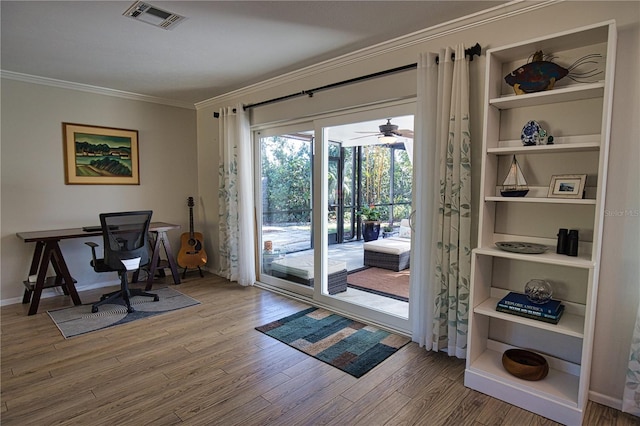 office area featuring baseboards, wood finished floors, visible vents, and crown molding