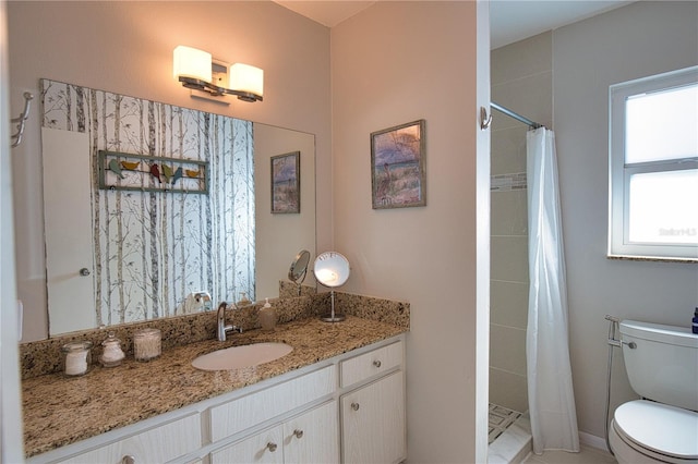 bathroom with vanity, a tile shower, and toilet