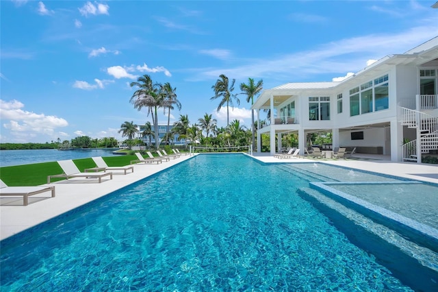 pool featuring a water view, a patio area, and stairway