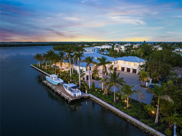 aerial view at dusk featuring a water view