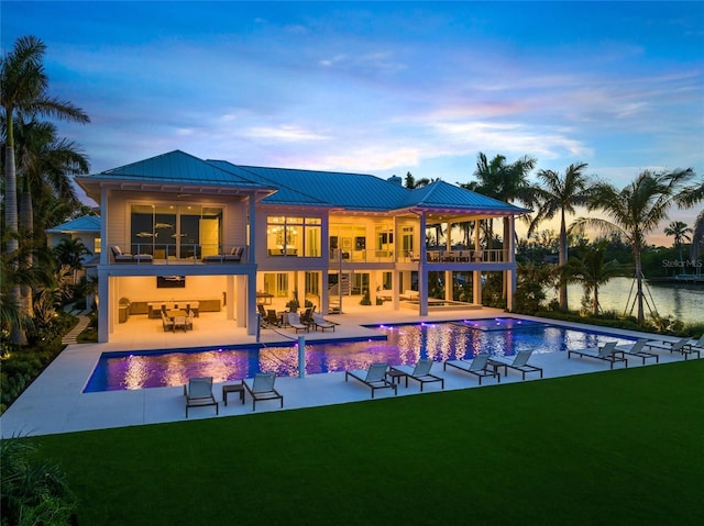 exterior space with an infinity pool, a patio area, a yard, and a balcony