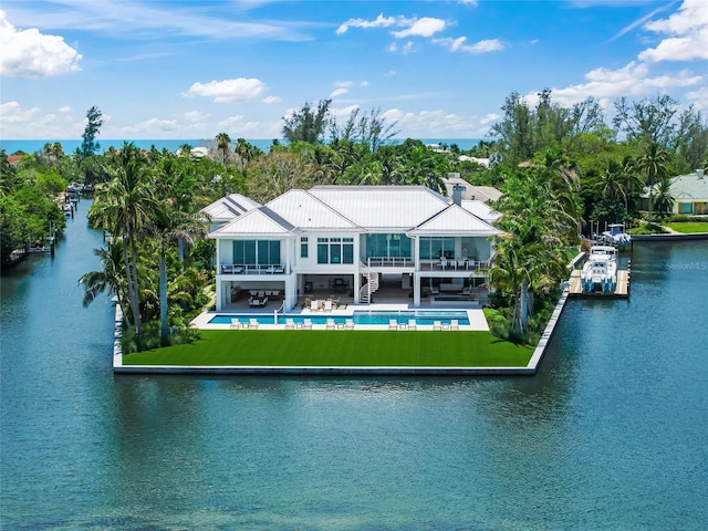 rear view of house featuring a patio area, stairway, a water view, and an outdoor pool