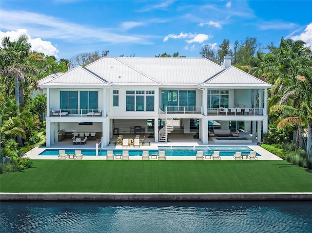 rear view of house featuring a lawn, a balcony, a water view, a patio area, and outdoor lounge area