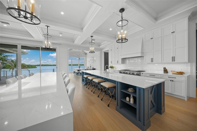 kitchen featuring open shelves, light wood-type flooring, custom exhaust hood, and white cabinets