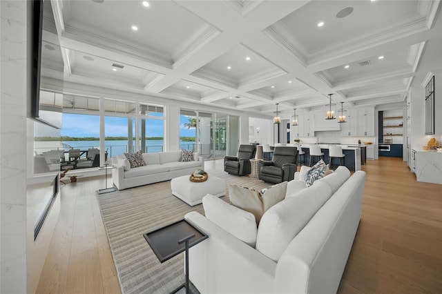 living area featuring light wood-type flooring, coffered ceiling, beamed ceiling, and visible vents