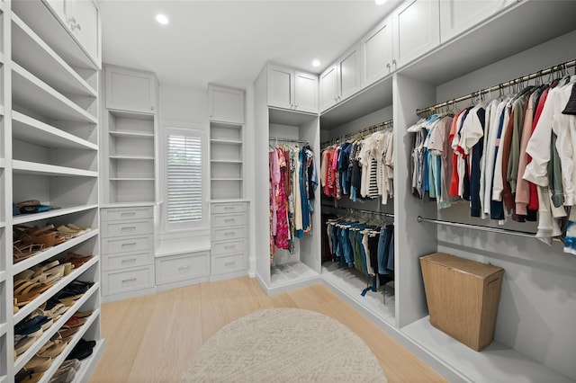 walk in closet with light wood-style flooring