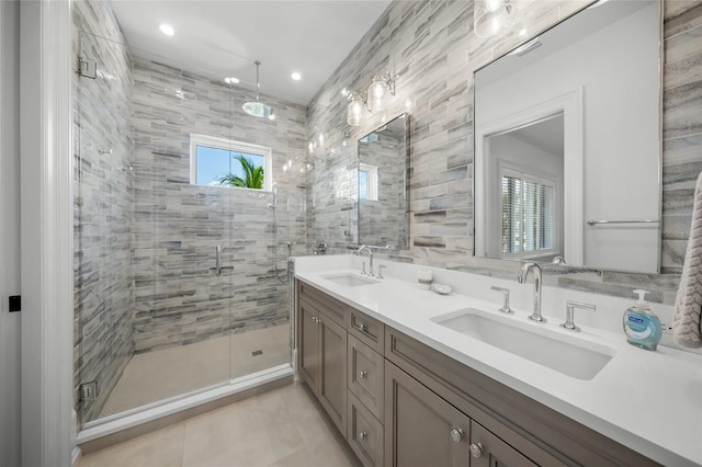 bathroom with a stall shower, tile patterned floors, a sink, and double vanity