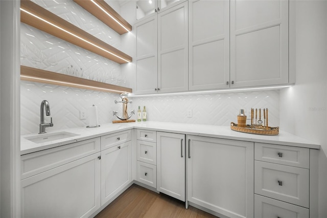 kitchen with white cabinets, a sink, backsplash, and open shelves