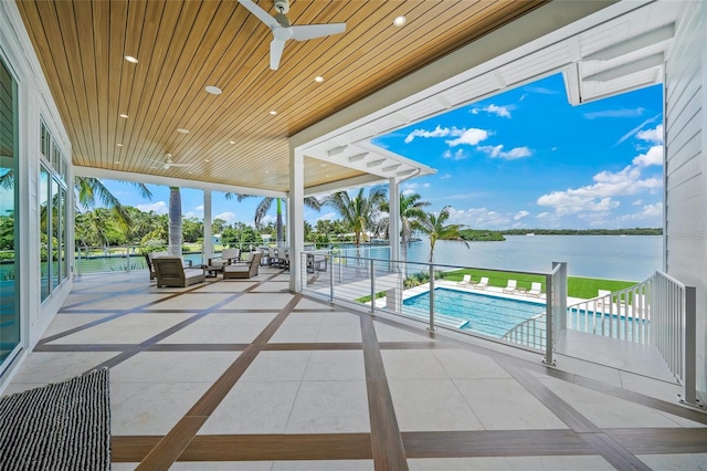 exterior space featuring a water view, ceiling fan, and a fenced in pool